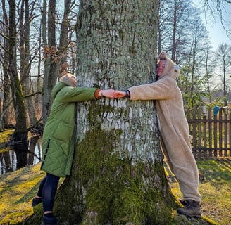 two women hugging the tree
