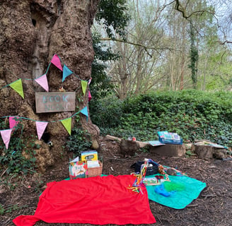 A blanket with books and sensory toys in an outdoor book nook