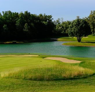 a golf course with a pond and a golf course Golf Club de lyon
