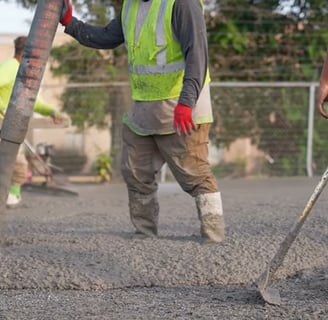 People using hand tools to spread the concrete