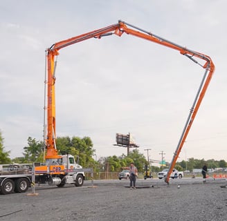 Long arm pouring concrete to finish the flat work
