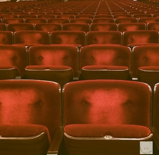 des sièges rouges en velours d'une salle de cinéema, chaise vide