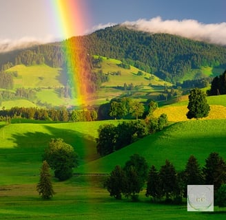 rainbow sur une campagne avec des champs verts vallonées et sous un ciel bleu et blanc