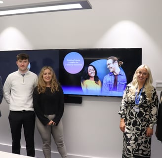 Three apprentices, a sales lead and Tim stand in front of a screen for UK&I apprenticship re-launch.