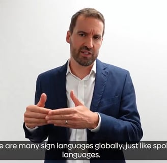 Rik Robarts a male in his mid forties sign languages to camera.