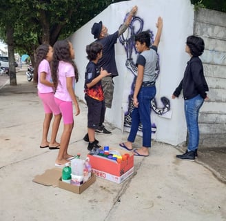 Grafite colaborativo – Adolescentes pintando em grupo na escola.