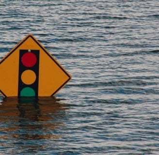 Street sign partially submerged under flood waters.