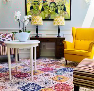 a living room with a yellow chair and a painting