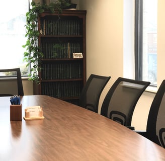 a conference room table with a bookcase and a television