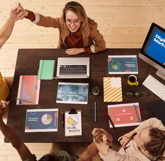 a group of people sitting at a table with laptops