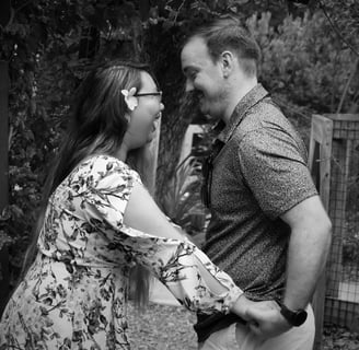 Engagement day photo of Sarah and Donny laughing and holding hands while looking at each other.
