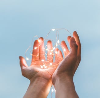a person holding a string light up to the sky