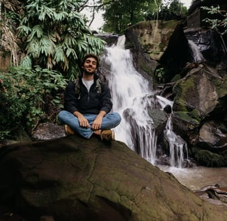 sitting on a rock in front of a waterfall in Nairobi