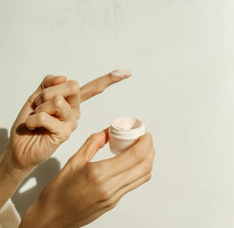 a woman holding a jar of cream open