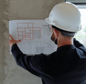 un operaio con il casco di protezione analizza un progetto