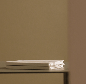 livres empilés sur un plateau minimaliste, reflétant l'élégance et la simplicité.