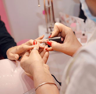 Lady applying red nail polish