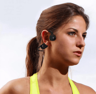 a woman in a yellow top and black earphones
