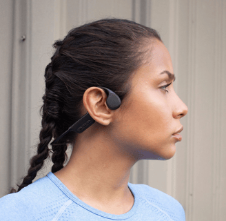 a woman with a blue shirt and earphones on