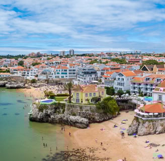 Drone aerial view of Praia da Rainha and historic city centre of Cascais, Portugal