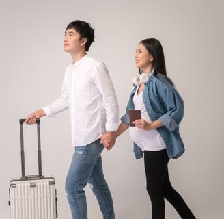 Pregnant couple with suitcase at airport