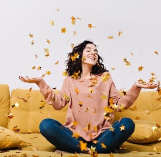 a woman sitting on a couch with her hands up and holding her hands out to