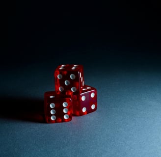 Three translucent red dice, stacked in a pyramid against a heavily shadowed backdrop.