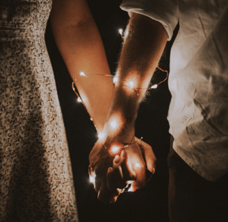holding hands with fairy lights wrapped around, healthy relationship