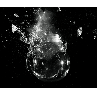 a glass bulb exploding against a dark background