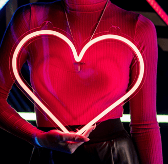 a woman holding a heart shaped light in front of her chest as a symbol of healing relational trauma