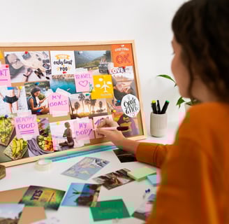 A girl is creating a vision board depicting one can achieve their goals by goal design and planning