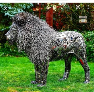 Lion grandeur nature sculpté en métal recyclé, avec détails élaborés sur la crinière, dans jardin
