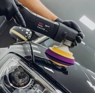 Professional car paint polishing with rotary machine for premium shine