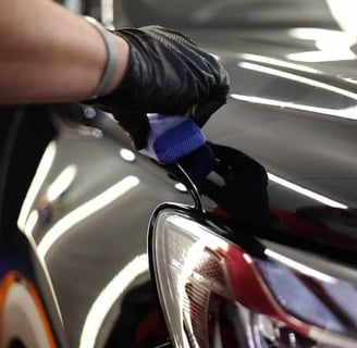 Technician restoring headlight clarity during professional detailing service.