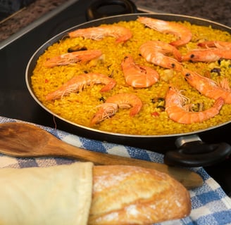 seafood paella next to a piece of bread