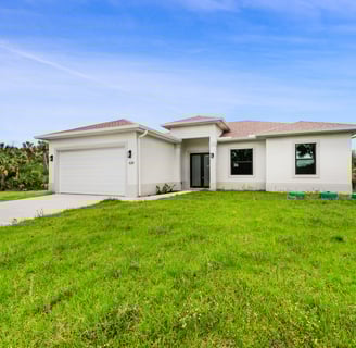 Single-family new construction home with landscaped front yard in Lee County, Florida.