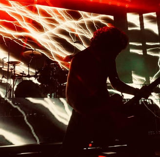 Groupe de métal Gojira qui agite les cheveux devant un visuel d'éclairs