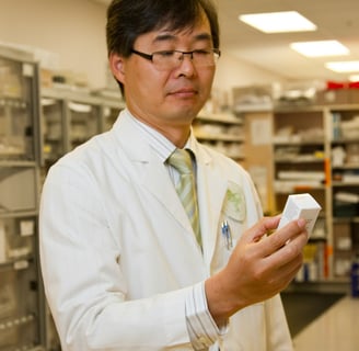 A pharmacist in a lab coat examining supplement ingredients for quality and safety