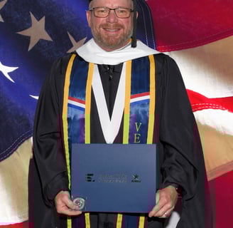 Andrew in full regalia after graduating with his Master's in Military and Trauma Psychology