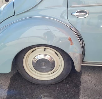 Enfoncement carrosserie sur l'aile arrière droite d'une Renault 4CV