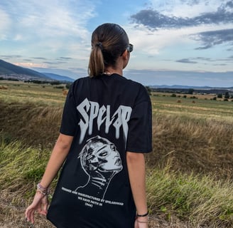 a woman in a black shirt and sunglasses is standing in a field