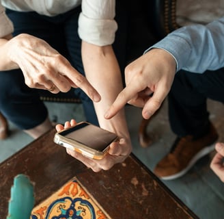 pessoas segurando um celular e apontando o aplicativo do serasa.