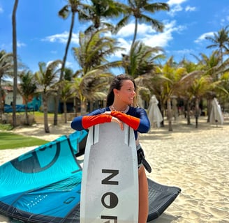 mulher com prancha de kitesurf na praia.