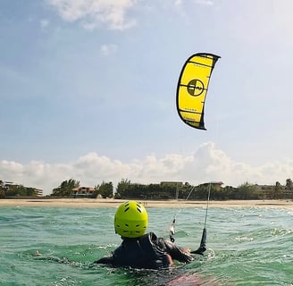 pessoa controlando o kitesurf dentro da água.