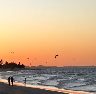 vista da praia do cumbuco no horario do sunset. Varios kites na água e pessoas passeando a beira mar