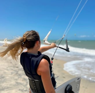 Mulher fazendo kitesurf na praia