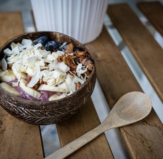 a bowl of fruit and nuts on a wooden table