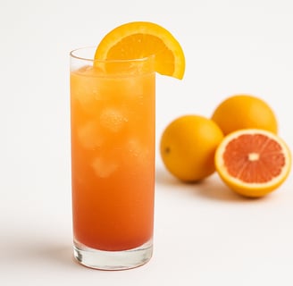 Orange drink with ice cubes and oranges in the background