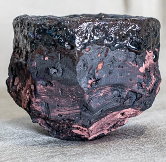 Yunomi cup made in Amman, Jordan, with rugged textures, charcoal body, and fire-kissed rose accents