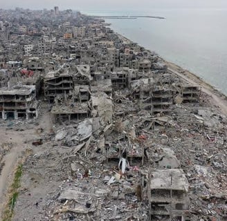 Aerial view of a heavily damaged urban area in Gaza, showing rubble and collapsed buildings, highlig